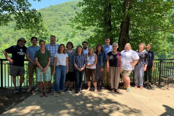 Group photo of researchers with wooded hills in the background